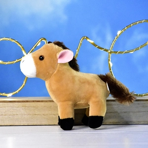 Détail de profil d'un mignon petit cheval en peluche marron avec museau blanc et LED