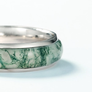Macro shot of silver ring featuring a translucent green moss agate stone inlay detail