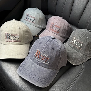 Detail of vintage washed cotton baseball caps with embroidered R'27 lettering on leather