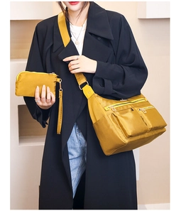 Close-up of ginger nylon crossbody bag with matching pouch and functional zipper pockets
