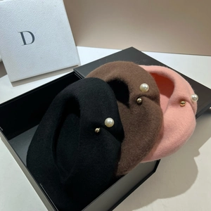 Detail of wool beret set in black, brown, and pink with pearl and gold accents