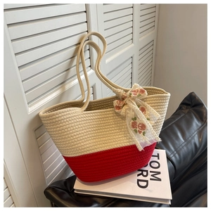 Detail of hand-woven tote bag with red stripes and floral lace bow accent