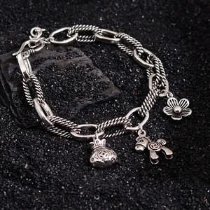 Retro silver charm bracelet with flower, money bag, and horse pendants in vintage style