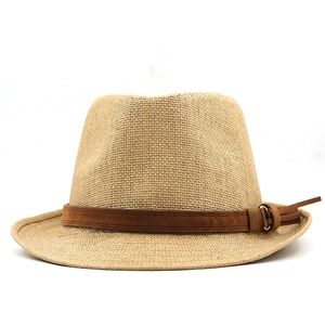 Close-up of tightly woven straw fedora hat with a dark brown buckled decorative band