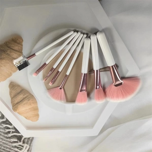 7pcs makeup brush set with pink bristles and white handles on a white hexagon tray