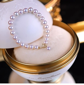 Detail of a vintage pearl bracelet with a golden spring clasp on a premium display
