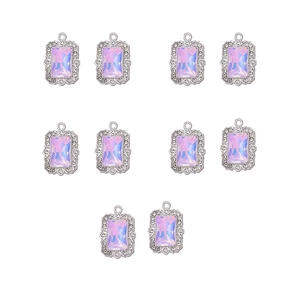 Close-up of ten silver filigree pendants with sparkling pink purple crystal stones