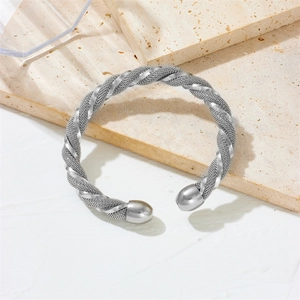 Silver C-shaped open bangle featuring a twisted spiral grid texture on marble background