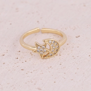 Detailed macro view of gold-plated star and moon ring with micro-pave white cubic zirconia