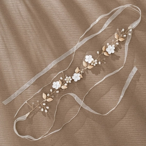 Handmade bridal headpiece with white clay flowers, pearls, and gold leaves on silk ribbon