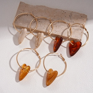 Three pairs of vintage acrylic heart hoop earrings in gold with amber and beige pendants