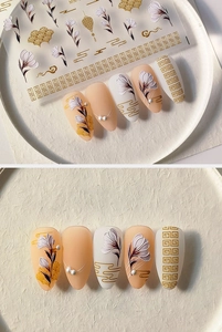 Macro shot of 5D embossed nail stickers featuring white floral and gold cloud patterns