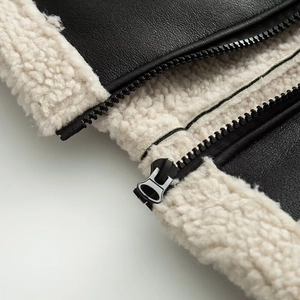 Detail of premium black faux leather jacket featuring white sherpa lining and metal zipper