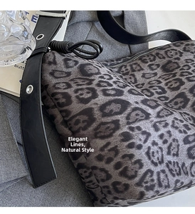 Close-up of leopard print tote bag texture with wide black leather shoulder strap