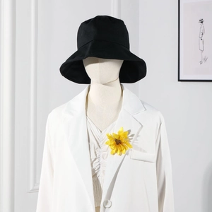 Detail shot of an elegant yellow acrylic flower brooch styled on a white blazer