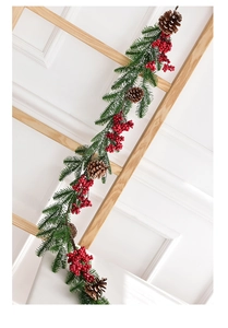 Detail of Christmas garland with pine needles, red berries and natural pine cones