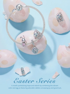 Détails macro d'un bracelet de Pâques en argent avec charms lapin et œufs sur fond bleu