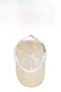 Detailed view of breathable mesh lining and reinforced inner seams of a beige baseball cap