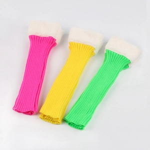 Close-up of knit leg warmers in pink, yellow and green with white faux fur trim tops