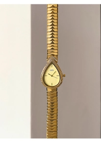 Detailed close-up of a golden pear-shaped quartz watch dial featuring sparkling rhinestones