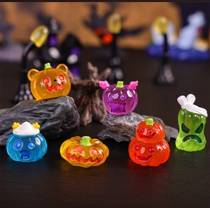 Macro shot of colorful resin mini pumpkins and ghost figurines for Halloween garden decor