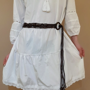 Detail of dark brown braided waist chain with wooden beads and tassels on white lace dress