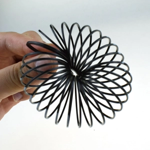 Close-up of black plastic slinky spring toy for Halloween with pumpkin and skull themes