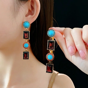 Vintage boho earrings featuring turquoise and ruby-colored stones in a gold geometric frame