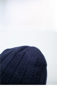 Dettaglio ravvicinato del berretto blu scuro con trama a maglia ondulata spessa invernale