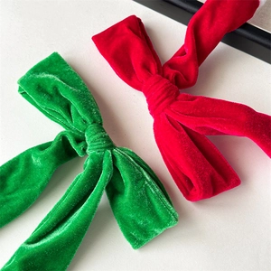 Detail of red and green velvet bow hair clips with white faux fur trim for Christmas