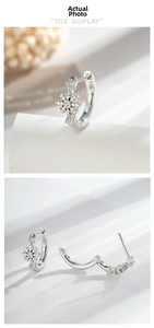 Détail macro de boucles d'oreilles créoles flocon de neige en argent avec zircons