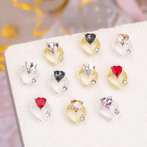 Detail of 3D hollow heart nail art charms with colorful rhinestones in gold and silver