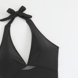Detail of black halter bikini top with bow tie, triangular cutout, and mesh lining