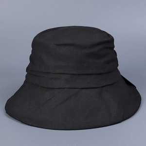 Detailed view of black sun hat featuring horizontal pleated fabric and cotton texture