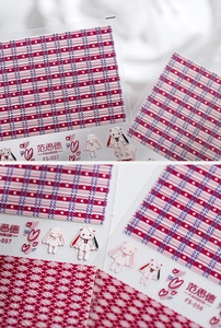 Macro detail of embossed nail stickers featuring plaid patterns and cute anime characters