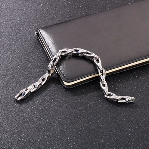 Silver stainless steel snake chain bracelet on black leather notebook and matte background
