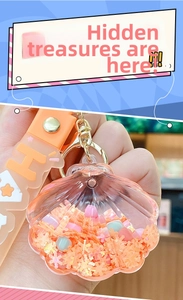 Detail of pink shell liquid keychain with floating beads and a golden D-ring buckle