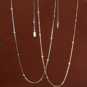 Minimalist stainless steel snake chain necklace with gold and silver bead accents
