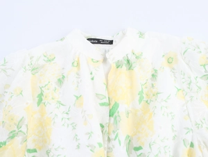Close-up of elegant V-neckline with yellow floral print and delicate fabric texture