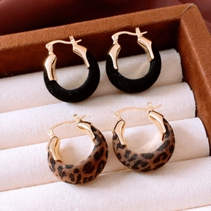 Gros plan de boucles d'oreilles rétro en velours noir et imprimé léopard dans un étui