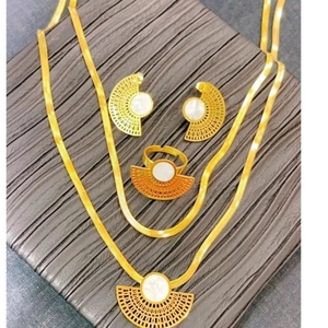 Macro shot of fan-shaped jewelry set with white shell inlay and gold plating