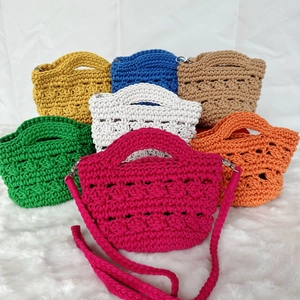 Detailed knit texture of colorful handmade crochet bags with woven shoulder straps