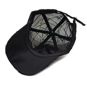 Detail of black baseball cap interior with breathable mesh texture and adjustable strap