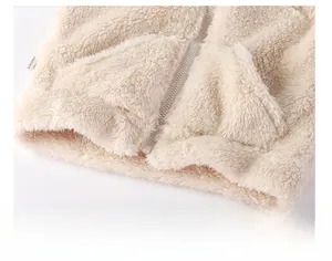 Dettaglio del gilet di peluche beige con cerniera, tasche e consistenza pile
