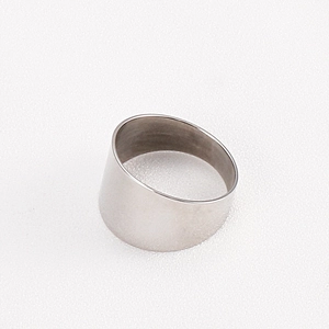 Macro view of wide silver titanium steel ring with polished finish on white texture