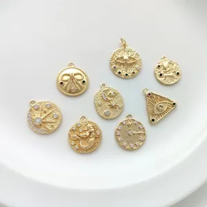 Macro detail of 14K gold plated charms with zircon eye, moon and clock relief