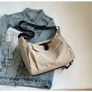 Flat lay of beige tote bag on denim jacket with a glass and book for lifestyle context