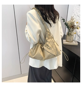 Close-up of lightweight nylon shoulder bag with drawstring detail and adjustable strap