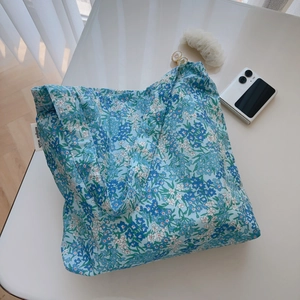 Close-up of a blue floral cotton tote bag featuring the simple wish side label