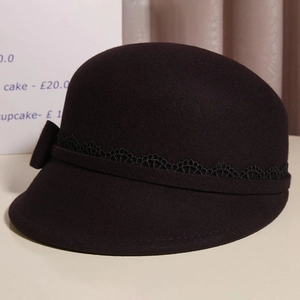 Close-up of deep brown wool equestrian hat with lace trim and delicate bow detail